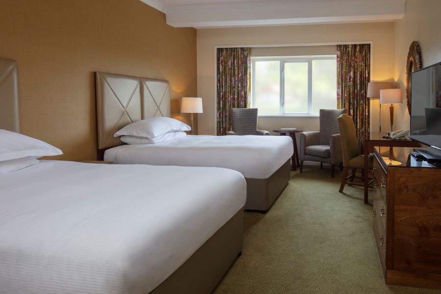 Twin beds in room with green carpet atSlaley Hall Hotel, Spa And Golf Resort