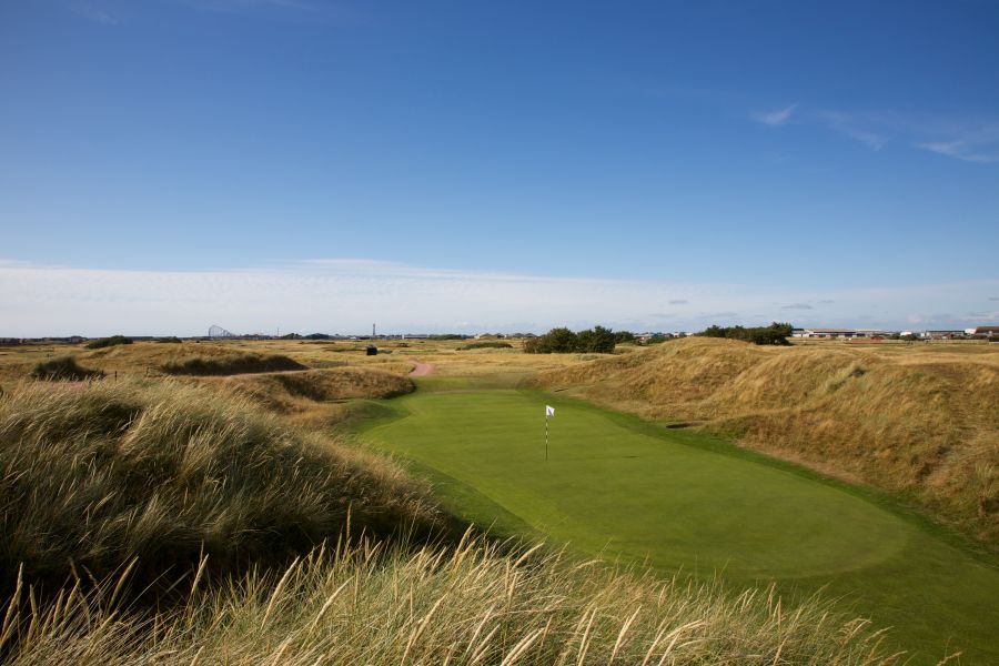 Putting green with white flag surrounded by links style rough at St Annes Old Links