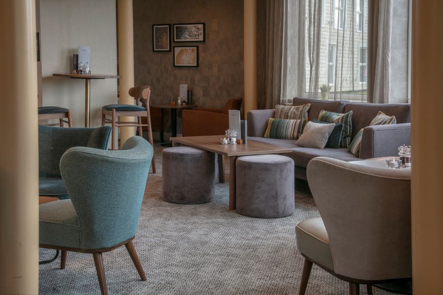 Green chair and grey stools in bar seating area at The Telford Hotel, Spa And Golf Resort