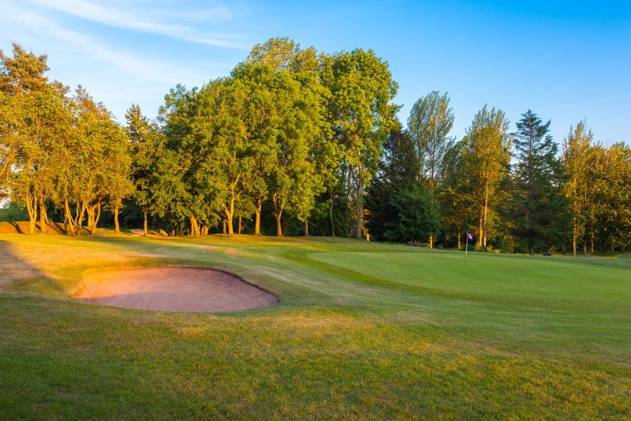 Bunker and green trees protecting the putting green with blue sky at The Telford Hotel, Spa And Golf Resort