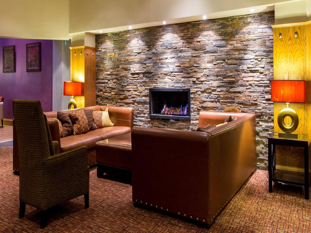 Leather sofas and fireplace in bar area at The Westerwood Hotel And Golf Resort