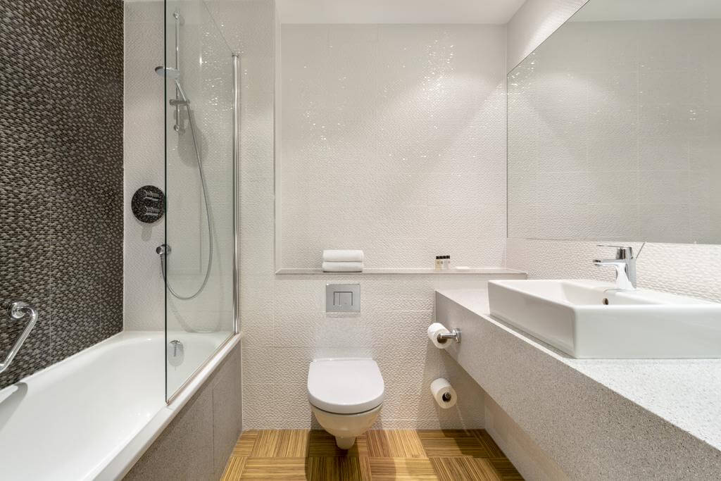 Bathroom with bath tub, sink, toilet and shower at Doubletree by Hilton Forest Pines Hotel and Golf Spa
