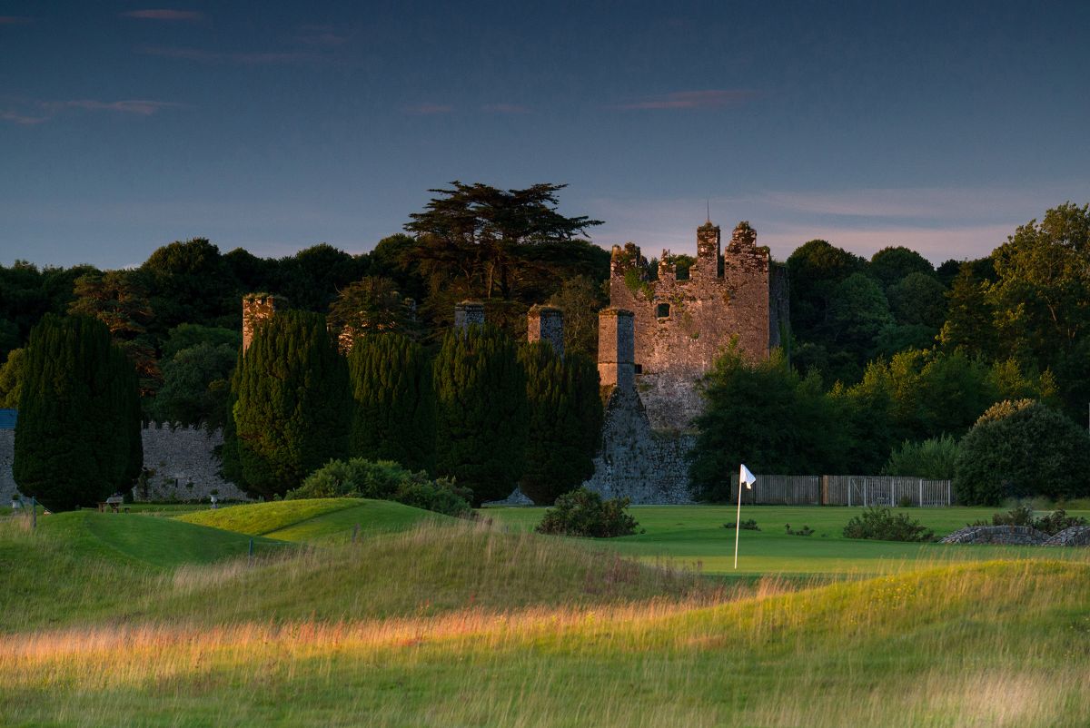 Castlemartyr Golf Club with flag on the putting green and ruins in the background