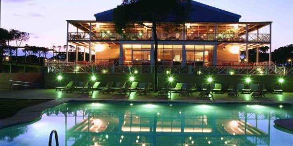 Rear of Hotel Nuevo Portil Golf ar night with swimming pool lit up