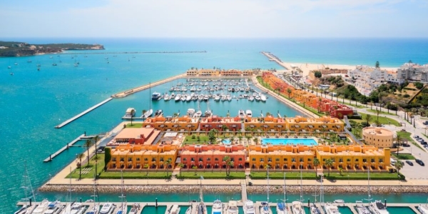 NH Marina Portimao Resort in the Algarve with multi-coloured apartments, blue sea, and yachts