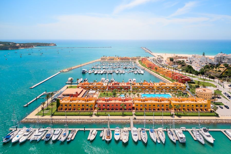 NH Marina Portimao Resort in the Algarve with multi-coloured apartments, blue sea, and yachts