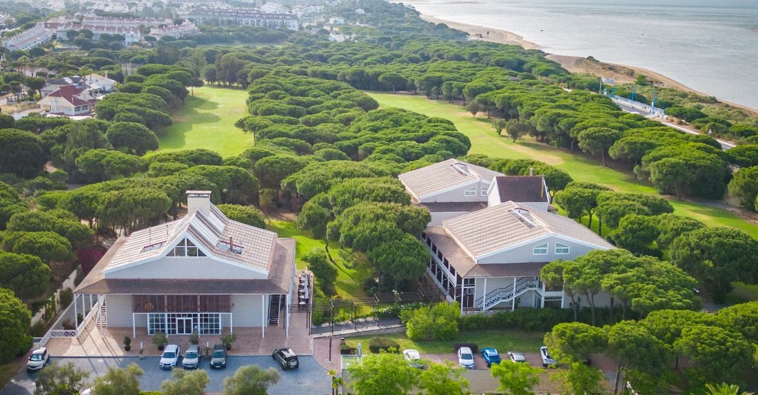 Hotel and clubhouse with car park in front at Nuevo Portil Golf in Costa De La Luz