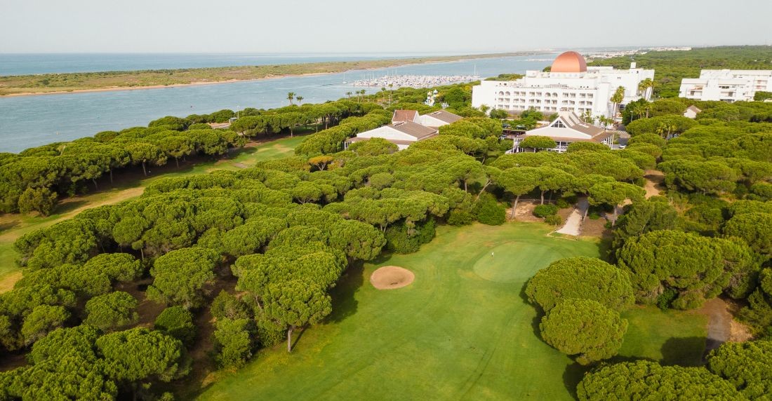 Fairway leading to the hotel at Nuevo Portil Golf with sea in distance