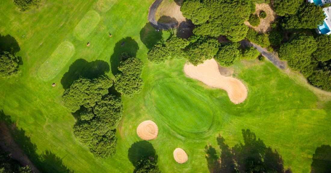 Overhead shot of putting green surrounded by one large bunker and two smaller ones at Nuevo Portil Golf in Costa De La Luz, Spain