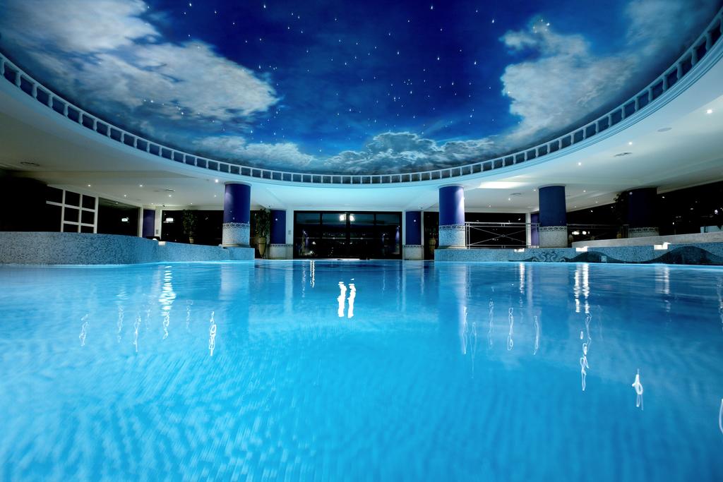 Heated indoor swimming pool with sky themed ceiling at Celtic Manor Golf Resort