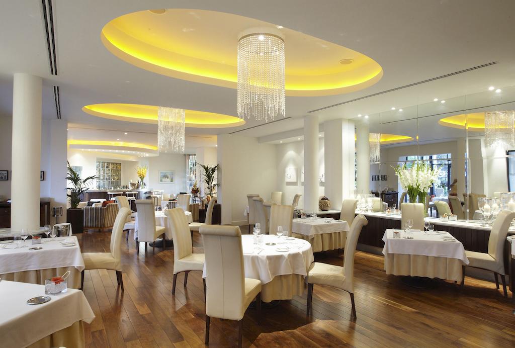 Restaurant with cream coloured chairs and tables set for guests at Celtic Manor Golf Resort