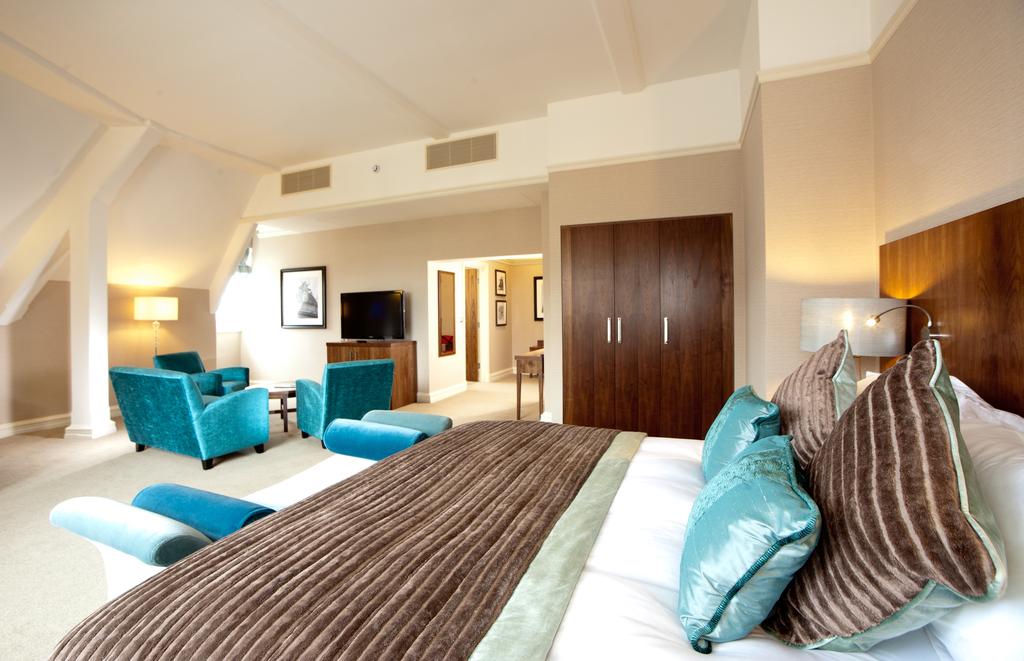 Luxurious double bedroom at The Grand York hotel with sofa and chairs