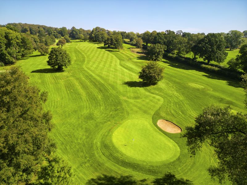 Putting green with sand bunker and trees protecting it at Delta Hotels by Marriott Breadsall Priory Country Club