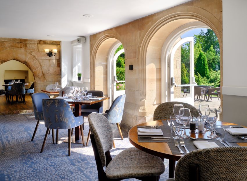 Restaurant with floor to ceiling windows at Delta Hotels by Marriott Breadsall Priory Country Club