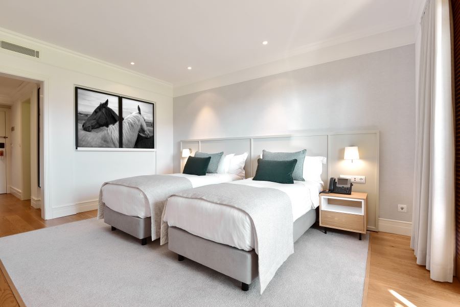 Two pictures on wall and twin beds in premium golf view room at Dolce by Wyndham CampoReal Lisboa