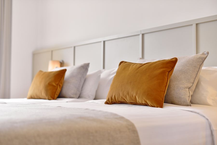Orange cushions on the bed at Dolce by Wyndham CampoReal Lisboa