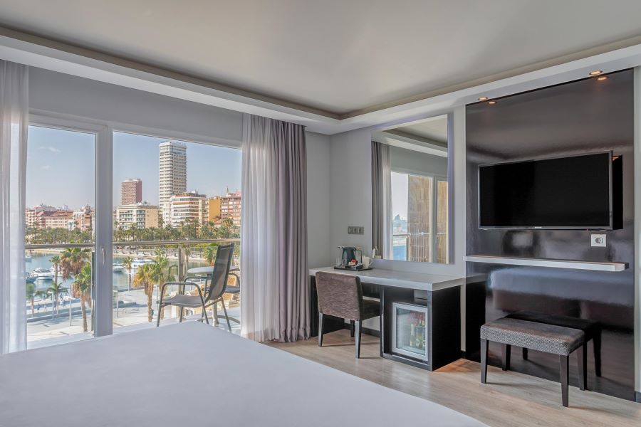 Desk, chair, minibar and television in bedroom at Melia Alicante Hotel