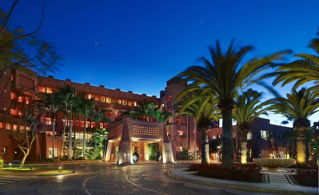 Entrance of The Ritz-Carlton Abama Resort at night with palm trees