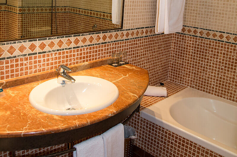 Bathroom at Hotel Nuevo Portil Golf with tiled bath and sink