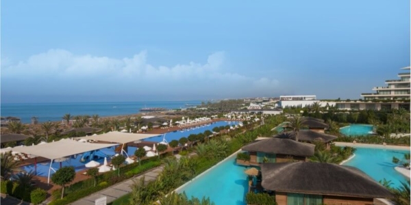 View of the outdoor swimming pools at Maxx Royal Golf And Spa Resort with the beach and sea in the distance