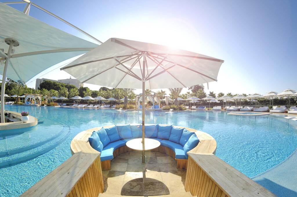 Private booth with parasol by the swimming pool at Regnum Carya Golf And Spa Resort