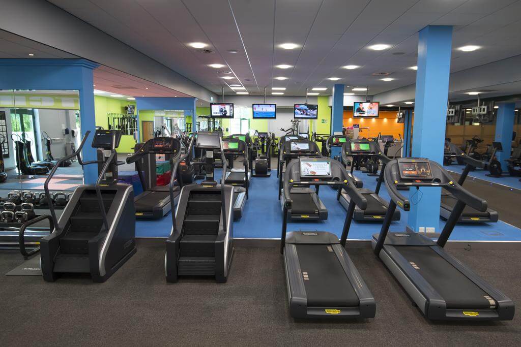 Gymnasium with cardio machines and television screens at The Vale Resort Wales