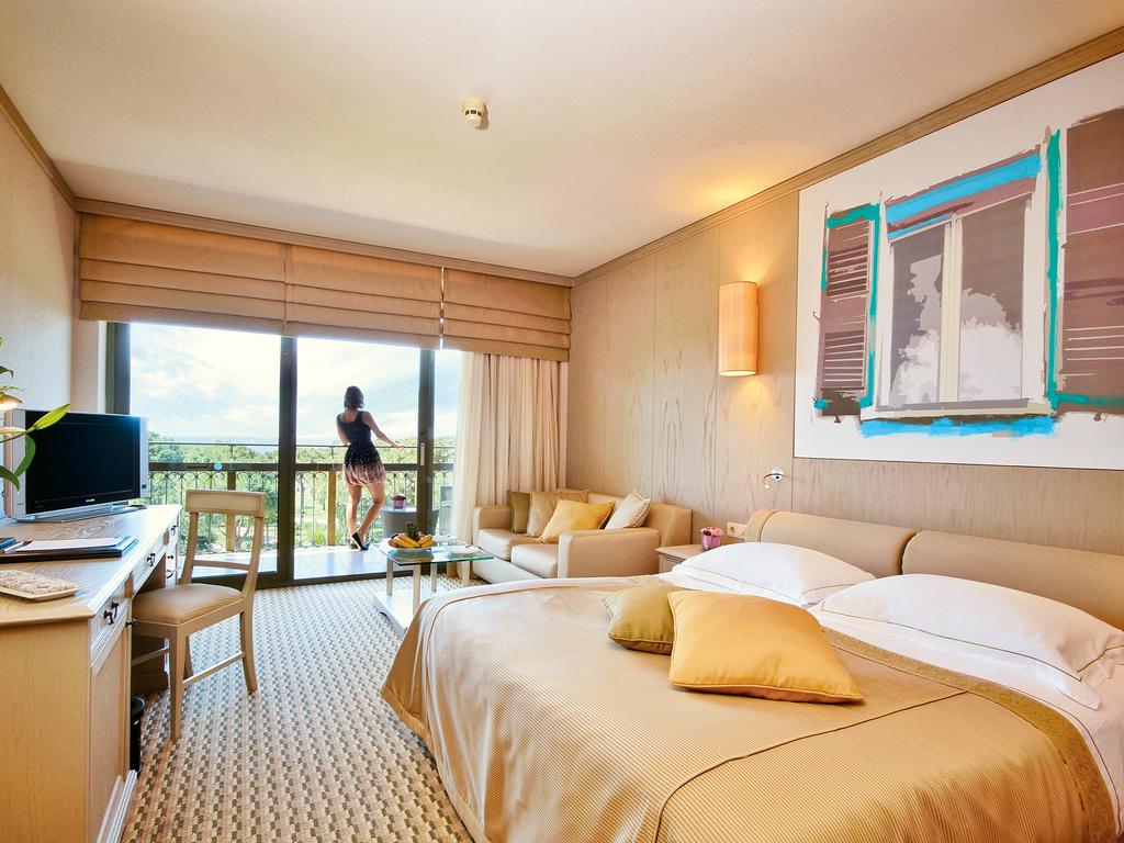Double bedroom at Gloria Golf Resort with guest looking out from private balcony