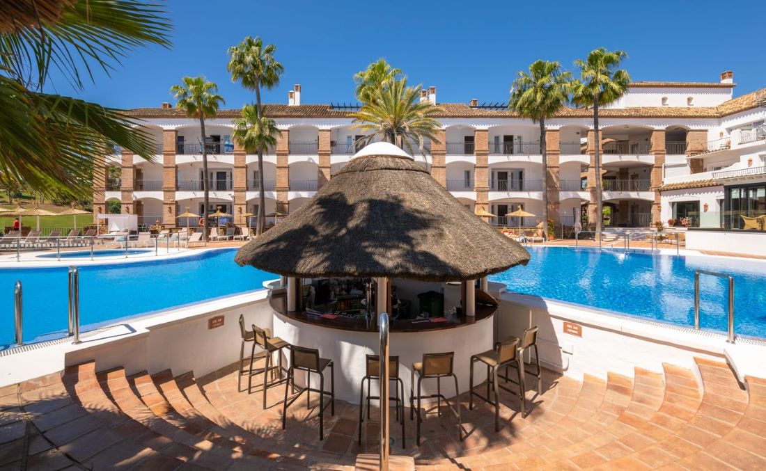 Pool bar with stools and straw roof at La Cala Golf Resort