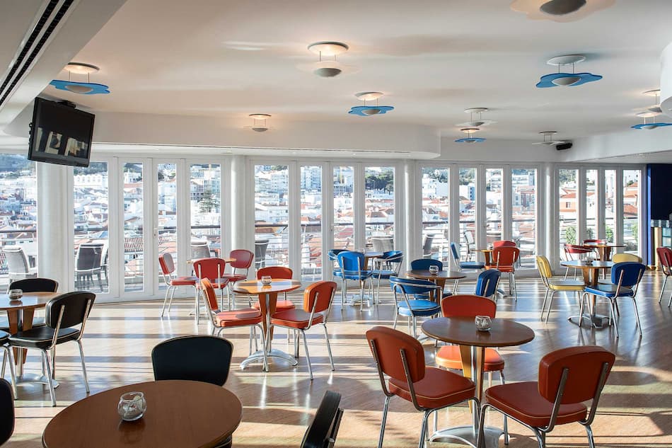 Bar area with blue and orange seats at Sana Sesimbra Hotel in Lisbon