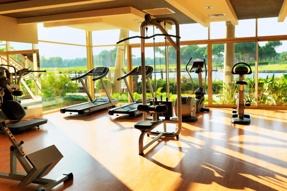 Cardio and weight machines in the gym overlooking the lake at Sueno Golf Hotel Belek