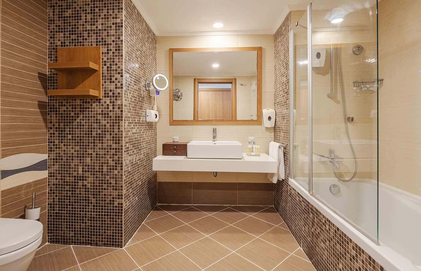 Bathroom with sink, bath tub, shower and toilet at Sueno Golf Hotel Belek