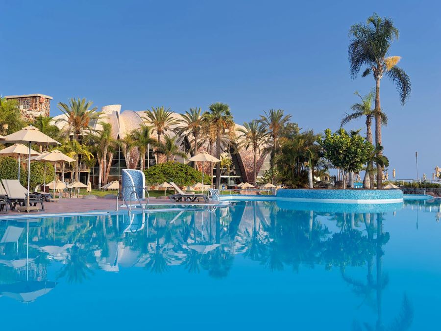 Palm trees surrounding the swimming pool at H10 Playa Meloneras Horizons Collection in the Canary Islands