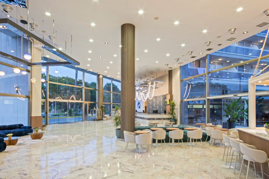 Lobby and reception with green chairs at Sol Costa Daurada by Melia