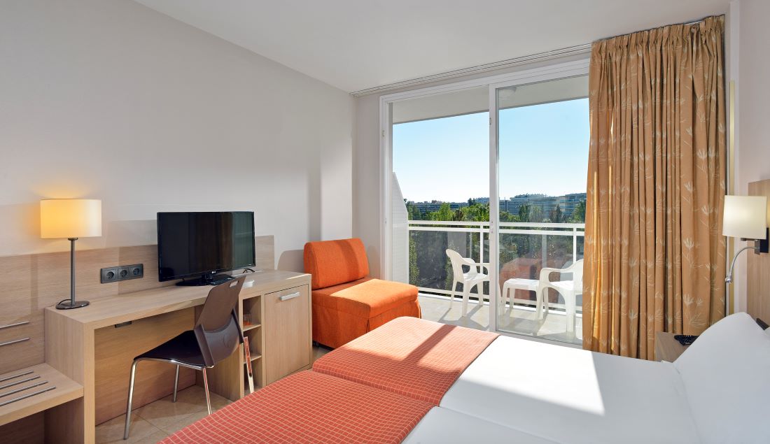 Bedroom with orange chair at Sol Costa Daurada