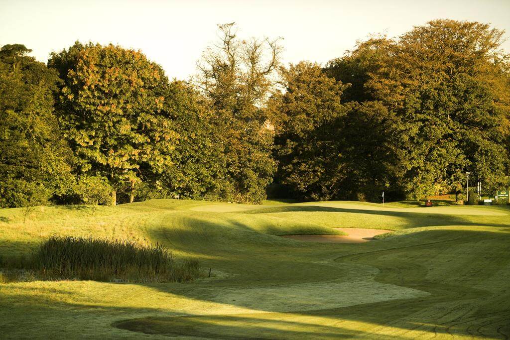 Fairway leading to the green which is protected by a bunker at Worsley Park Hotel & Country Club