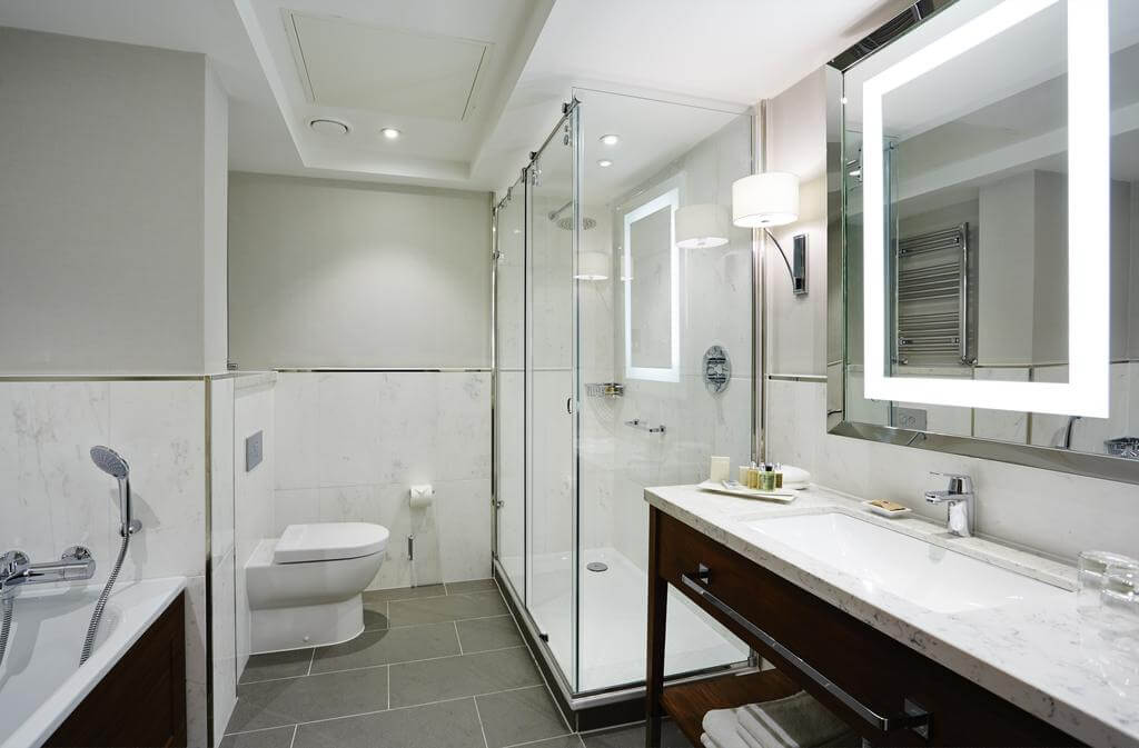 Bathroom with bath tub and separate shower cubicle at Hanbury Manor Golf Marriott Hotel And Country Club