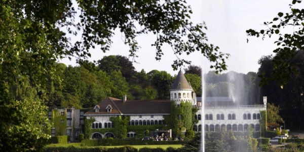 Exterior of Martin's Chateau Du Lac surrounded by trees and overlooking the lake and fountain