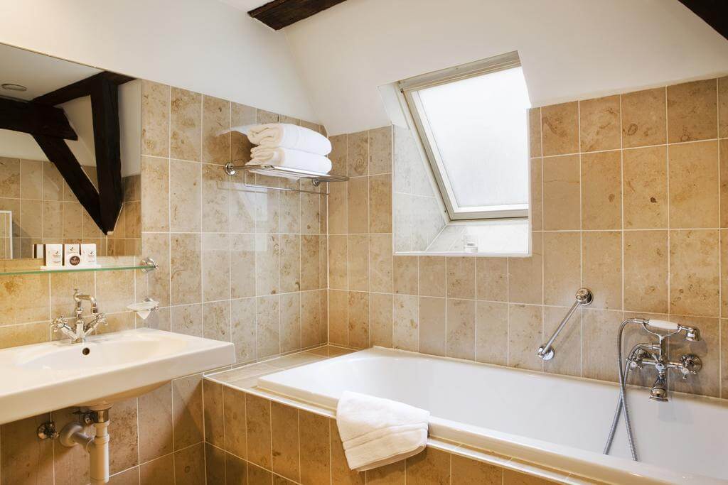 Tiled bathroom at Martin's Relais, sink, bath tub, toiletries and towels