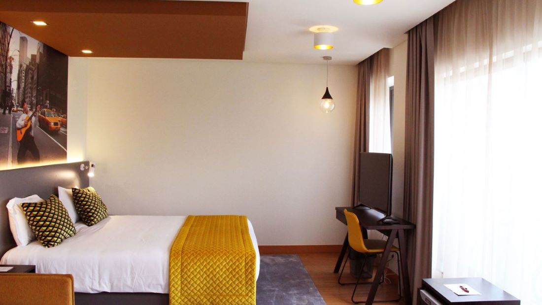 Standard bedroom at American Diamonds Hotel in the centre of Lisbon with double bed, desk and television