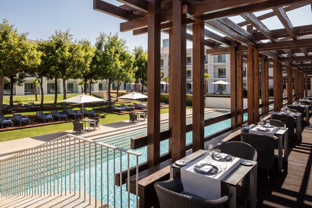 Tables and chairs in restaurant overlooking the pool at Anantara Vilamoura Algarve Resort
