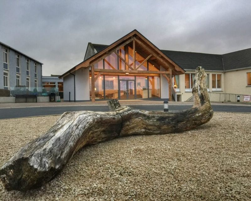 Log outside the illuminated entrance of Rosapenna Hotel And Golf Resort