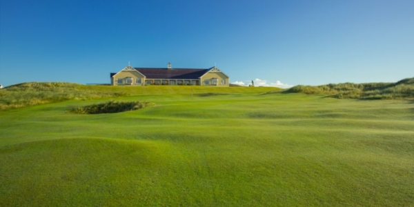 Clubhouse with blue sky and green fairway at Rosapenna Hotel And Golf Resort
