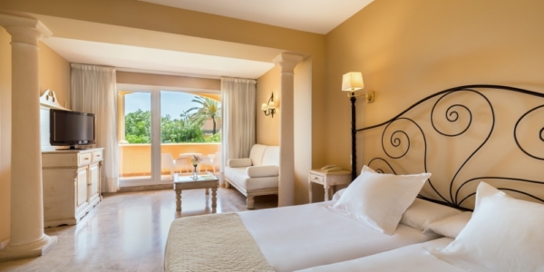 Bedroom with twin beds, sofa, flat screen television, and private balcony at Guadalmina Hotel Spa And Golf Resort