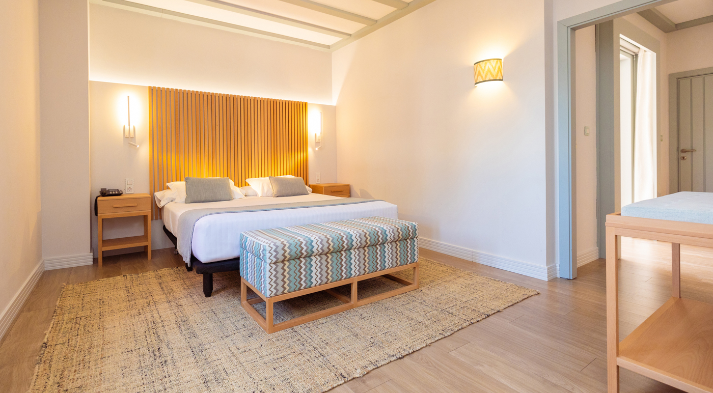 Bedroom at Hotel Isla Canela Golf Resort with wooden strips behind headboard and rug