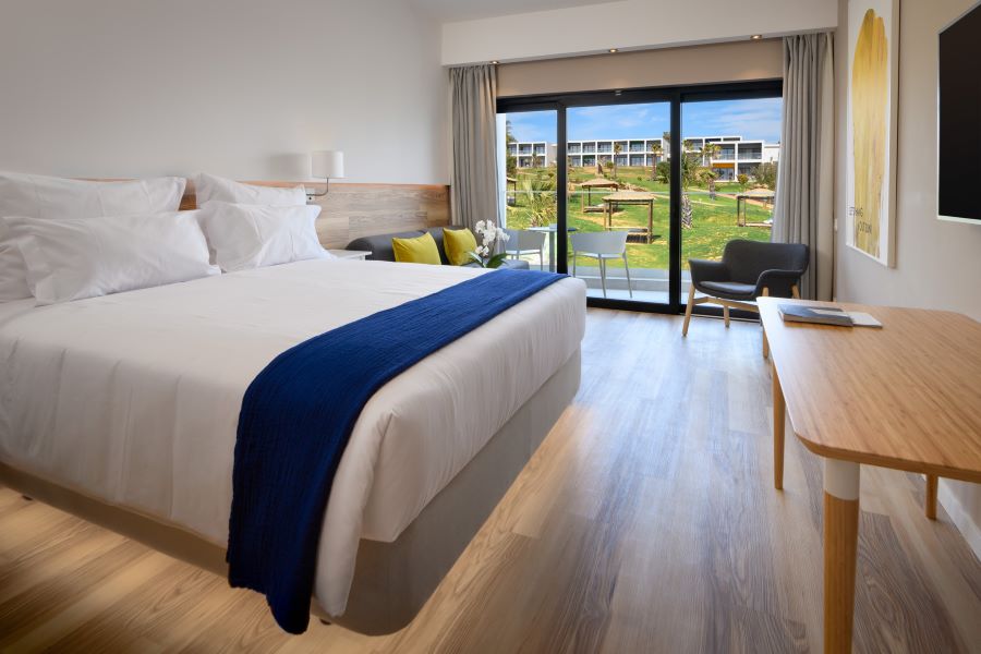 Bedroom with double bed and patio doors leading to view of resort