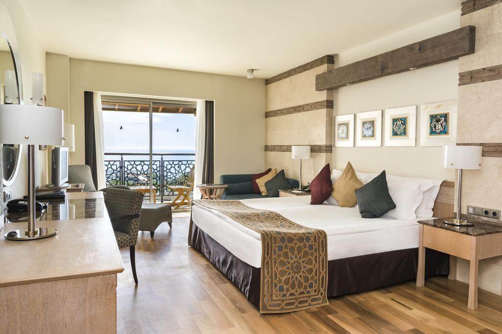 Double bedroom with sofa, desk and chair at Kempinski Hotel The Dome in Belek