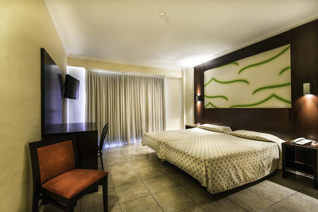 Bedroom with twin beds and flat screen television at Kn Columbus Aparthotel