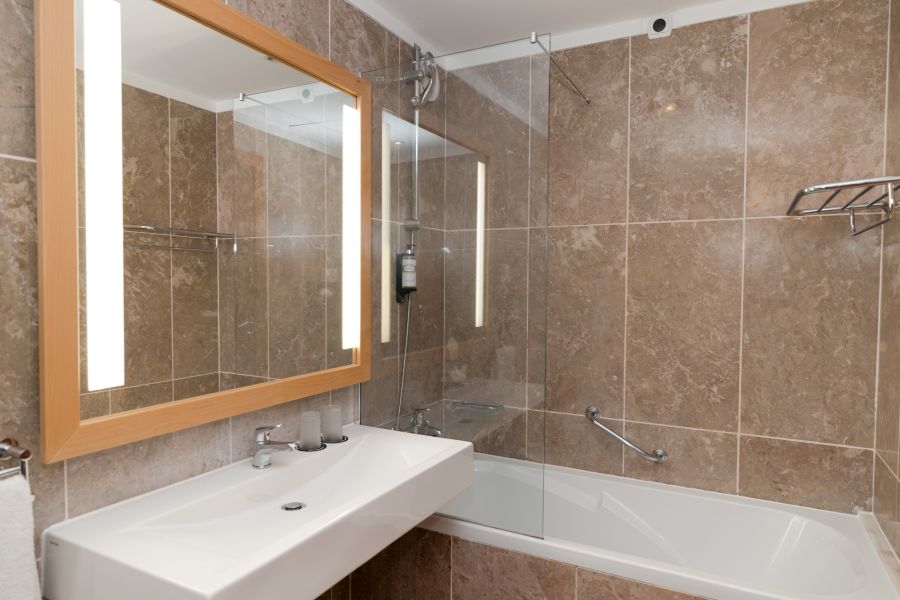 Bathroom with shower over bathtub at Pestana Viking Hotel