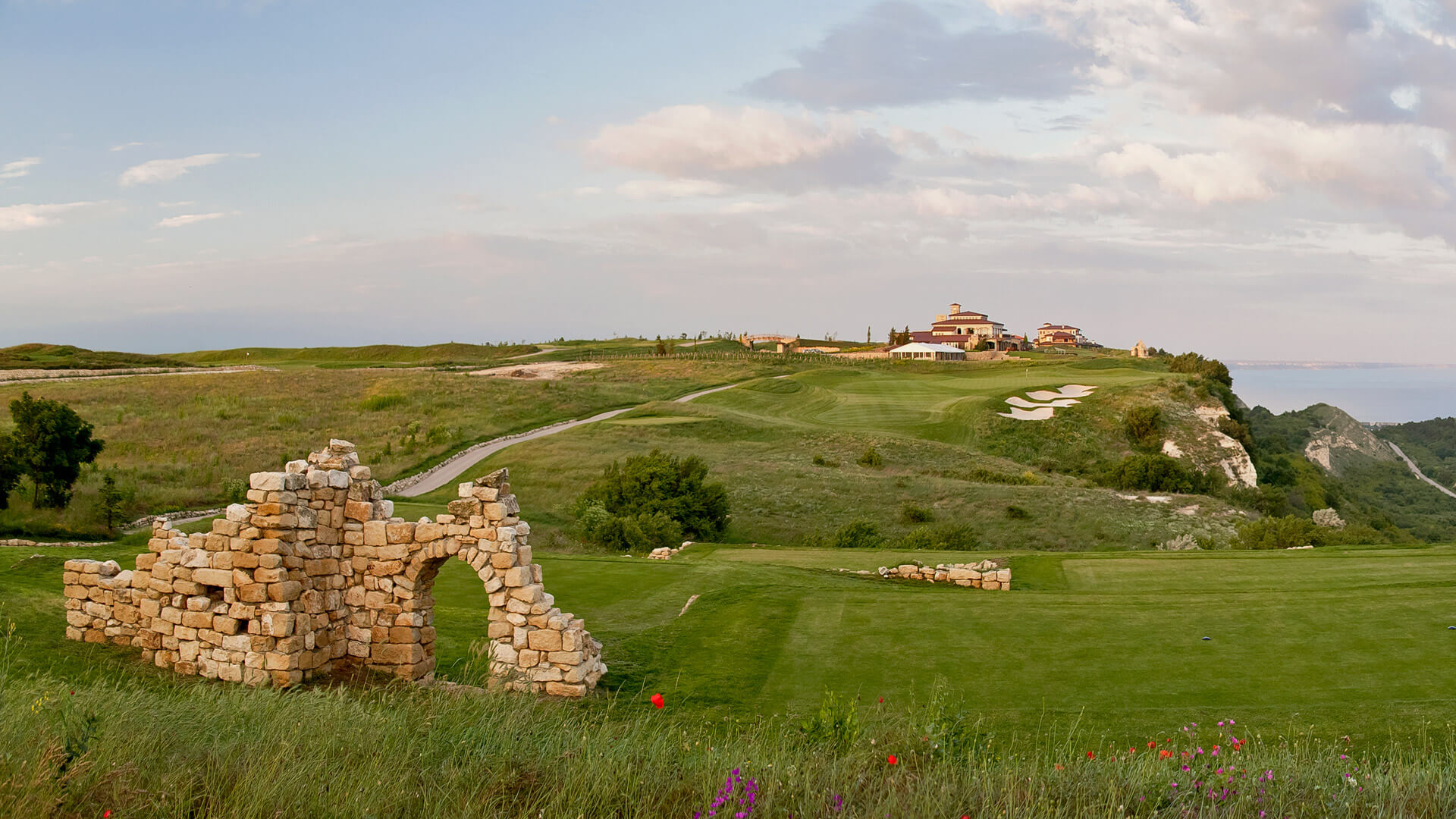 Ancient stone ruins on the tee at Blacksearama Golf and Villas golf course with resort and black sea in the distance