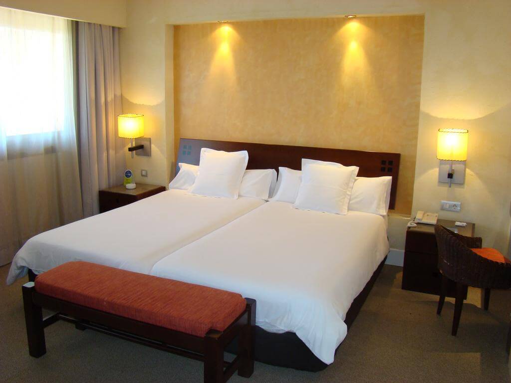 Bedroom with twin beds and bedside lamps turned on at DoubleTree by Hilton Islantilla Beach Golf Resort